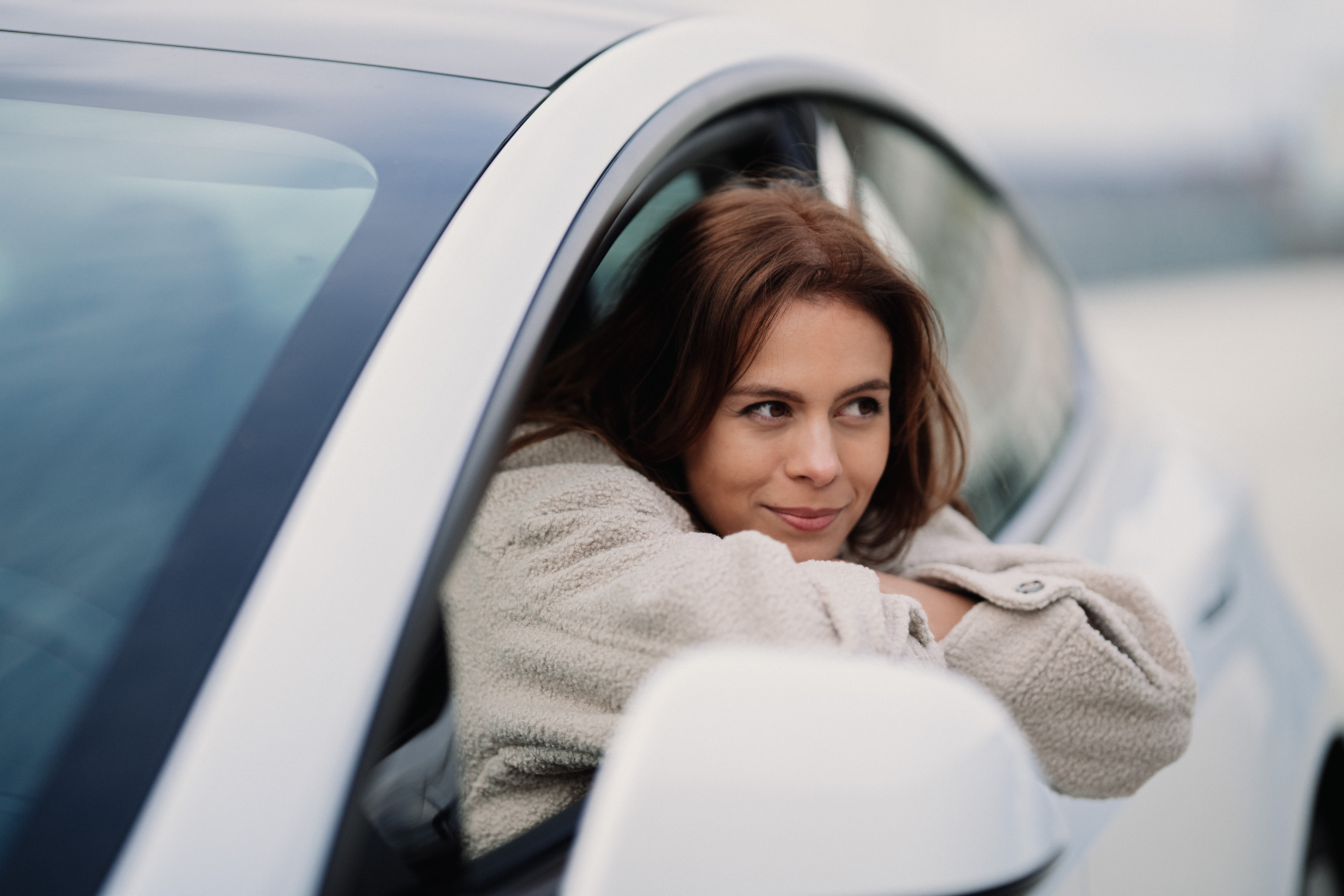 A lady leaning out of a vehicle window.