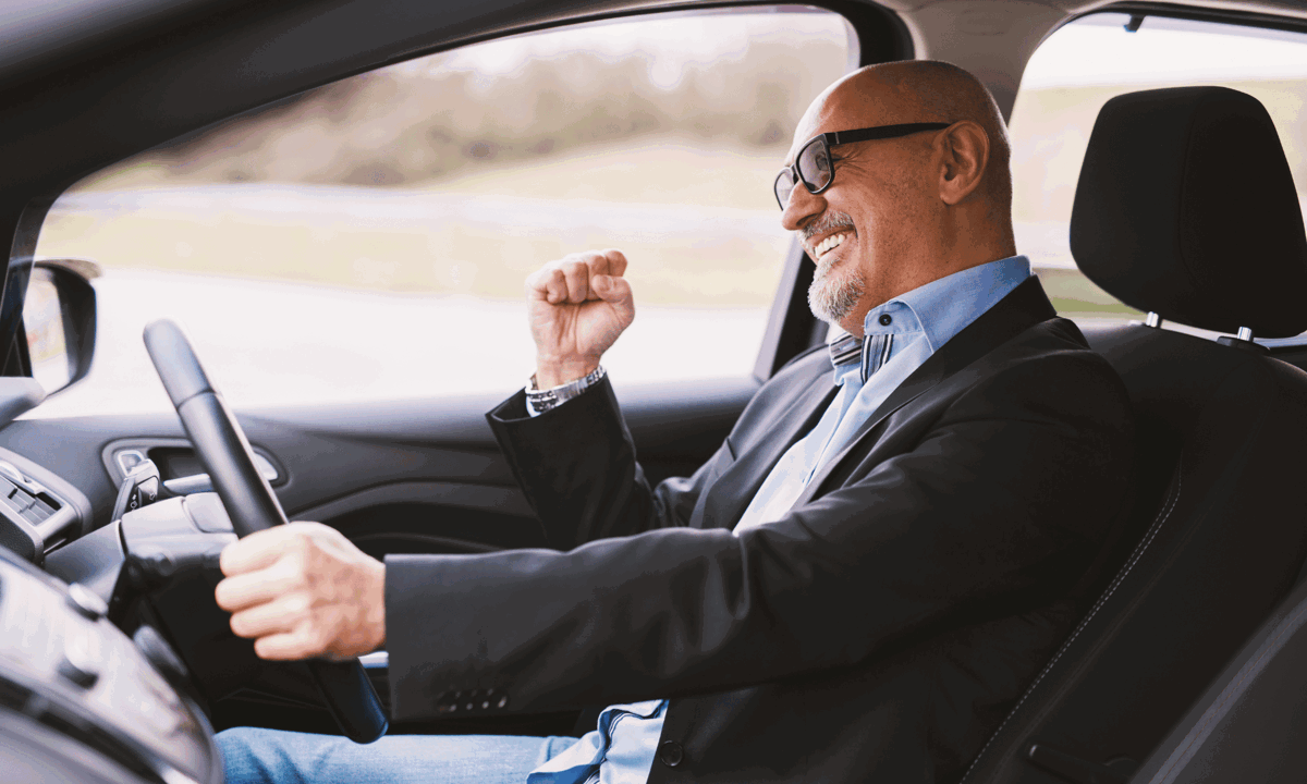 Man driving and smiling in suit