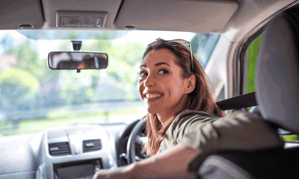 Lady in drivers seat looking over shoulder.png