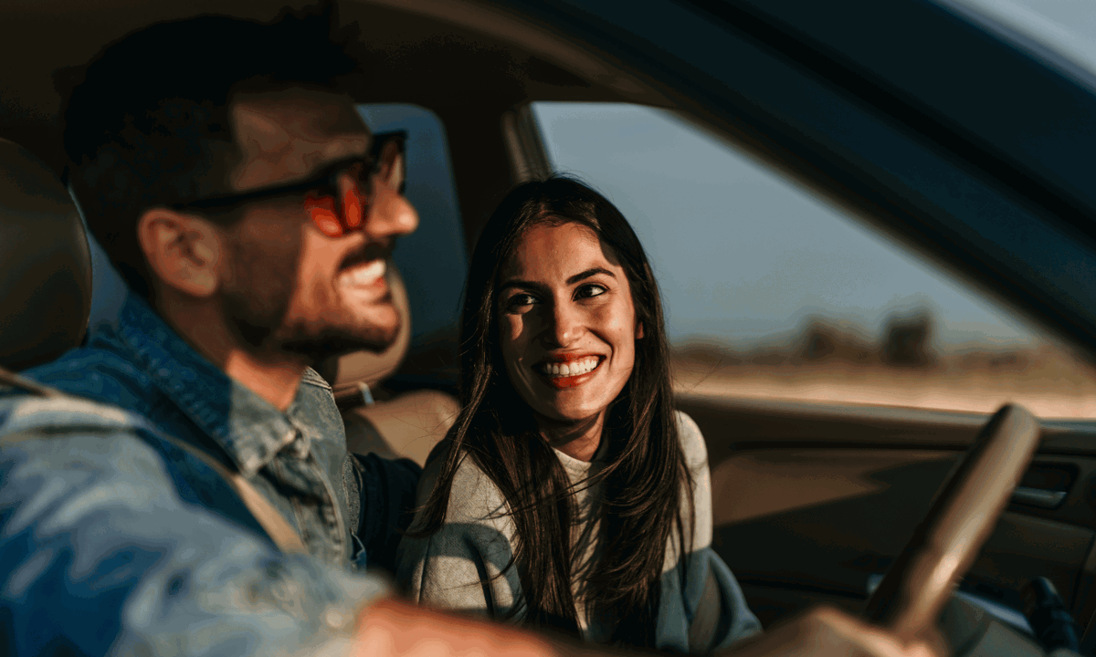 Woman smiling at man in a car