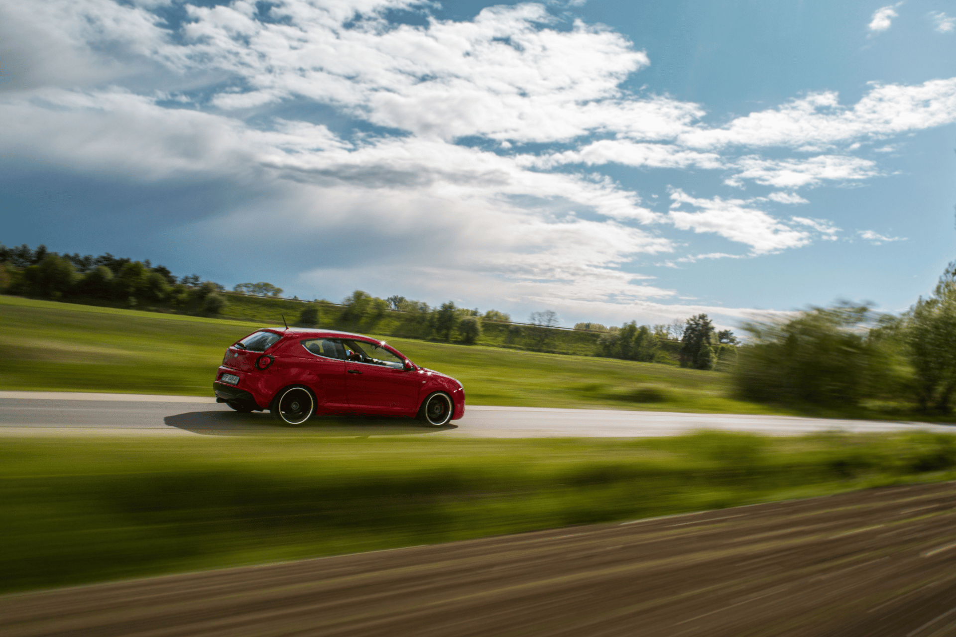 Alfa Romeo driving through countryside.