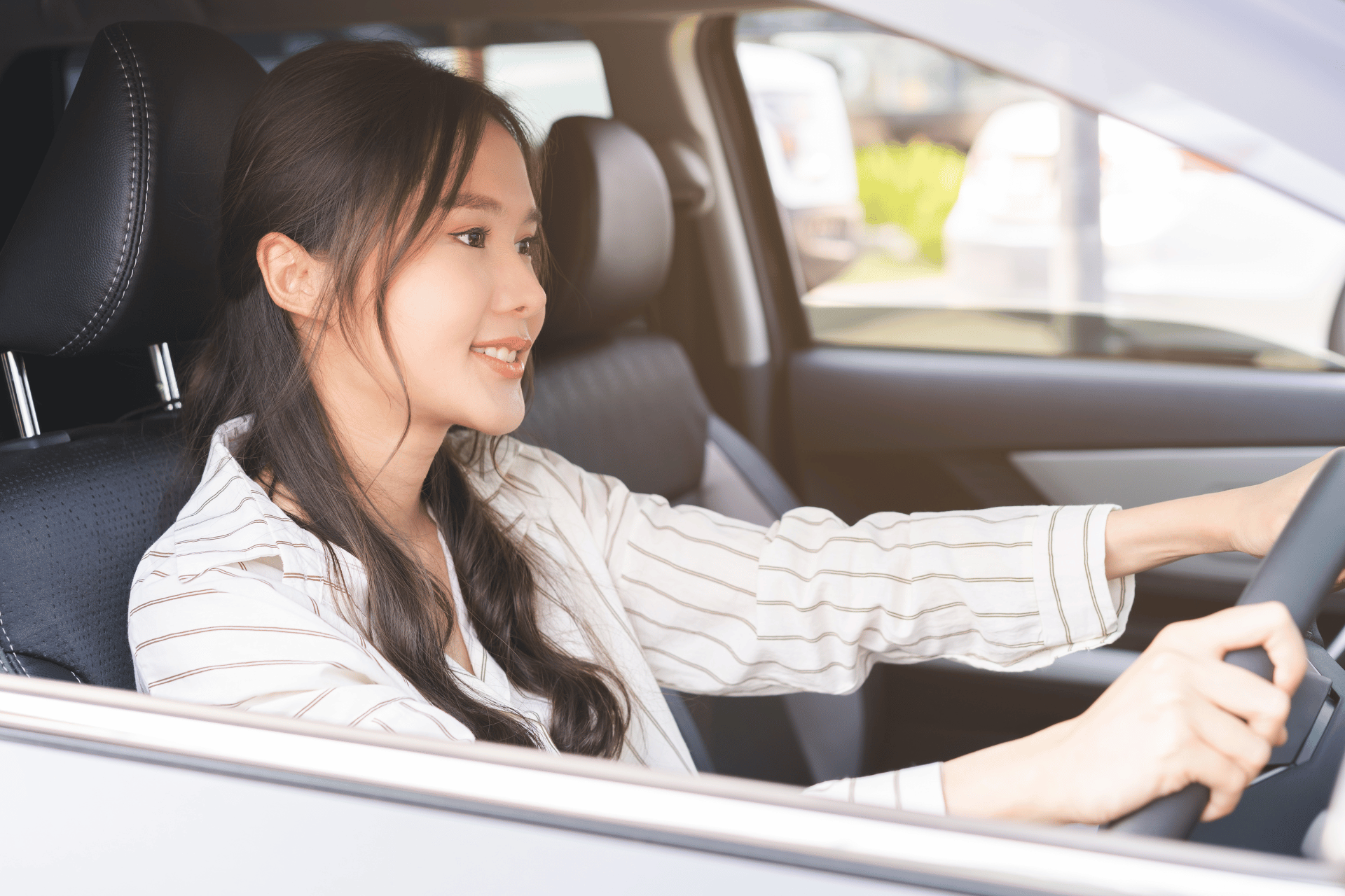 Smiling lady driving car.