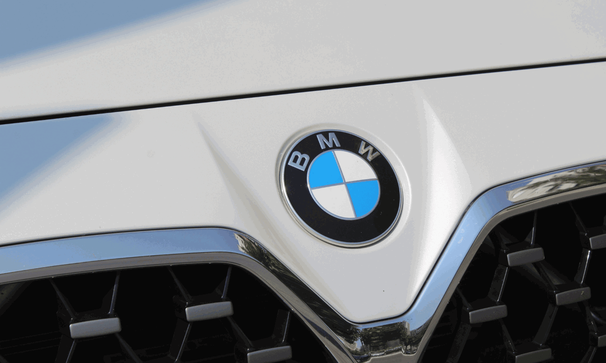 Front of white BMW showing badge.